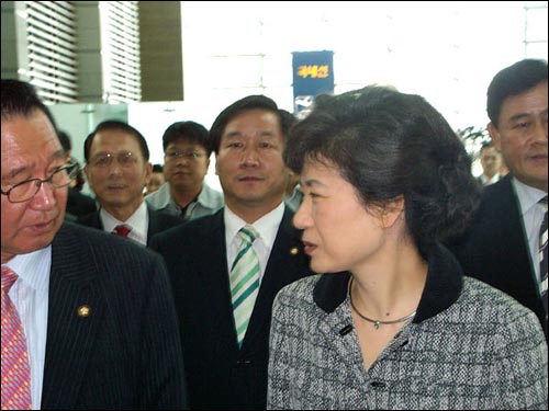 인천공항 입국통로를 걸어가며 인사하는 이규택 의원과 박근혜 전 대표 